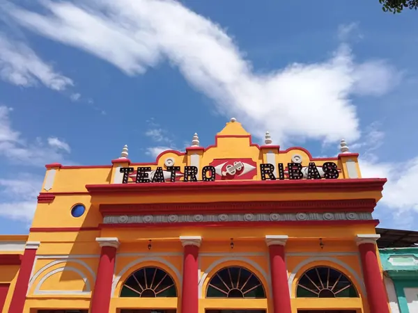Fachada principal del Teatro Ribas en plena luz del día, contrapicado sobre cielo azul