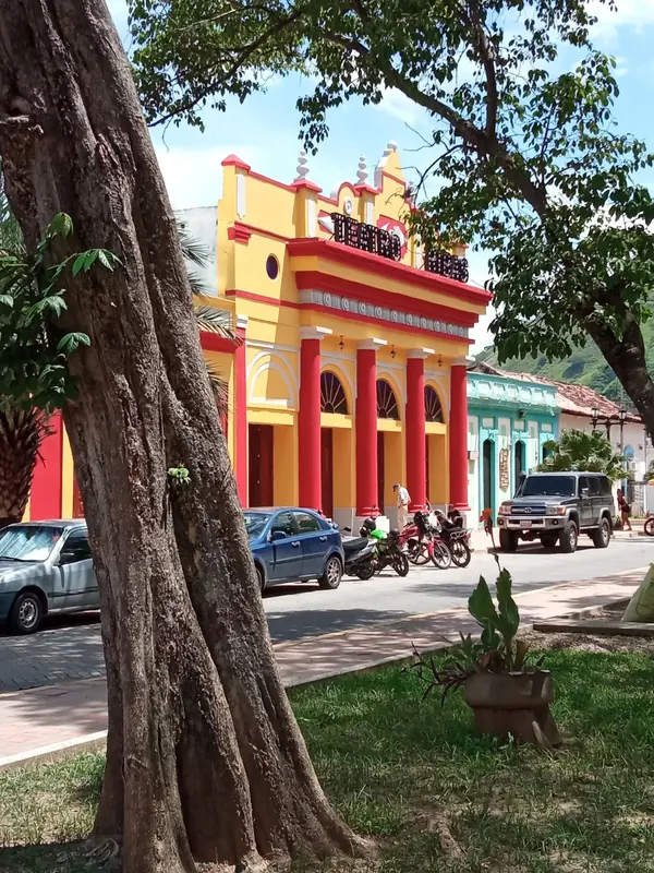 El Teatro Ribas visto desde la Plaza José Félix Ribas, enmarcado por árboles