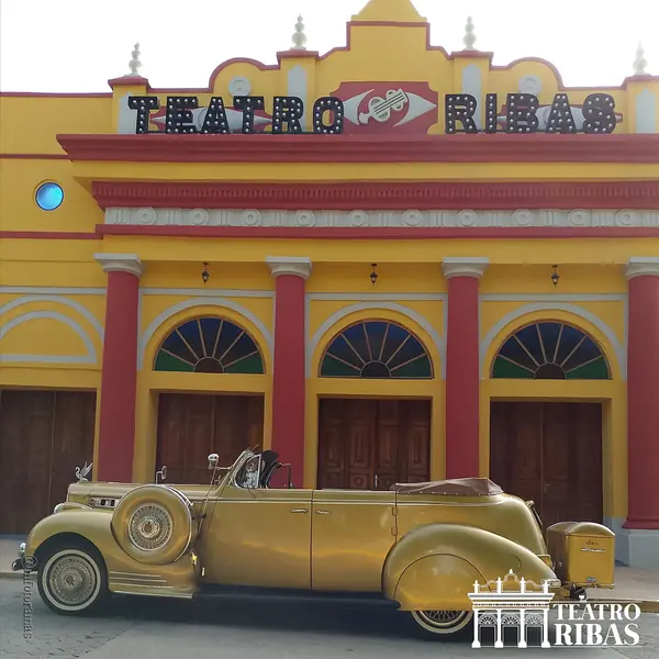 Fachada del Teatro Ribas con un Packard descapotable dorado clásico al frente
