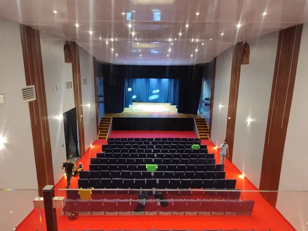 Vista panorámica del interior del Teatro Ribas desde el balcón hacia el escenario con telón azul